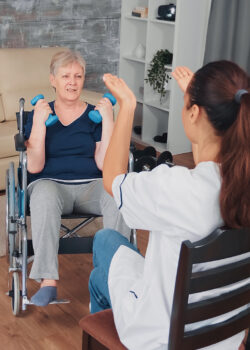 Invalid old woman in wheelchair doing rehab training with support from doctor. Disabled handicapped old person recovering professional help nurse, nursing retirement home treatment and rehabilitation